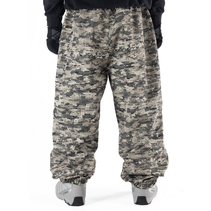 green and tan camo Howl snowboard pants on model witha loose fit back view