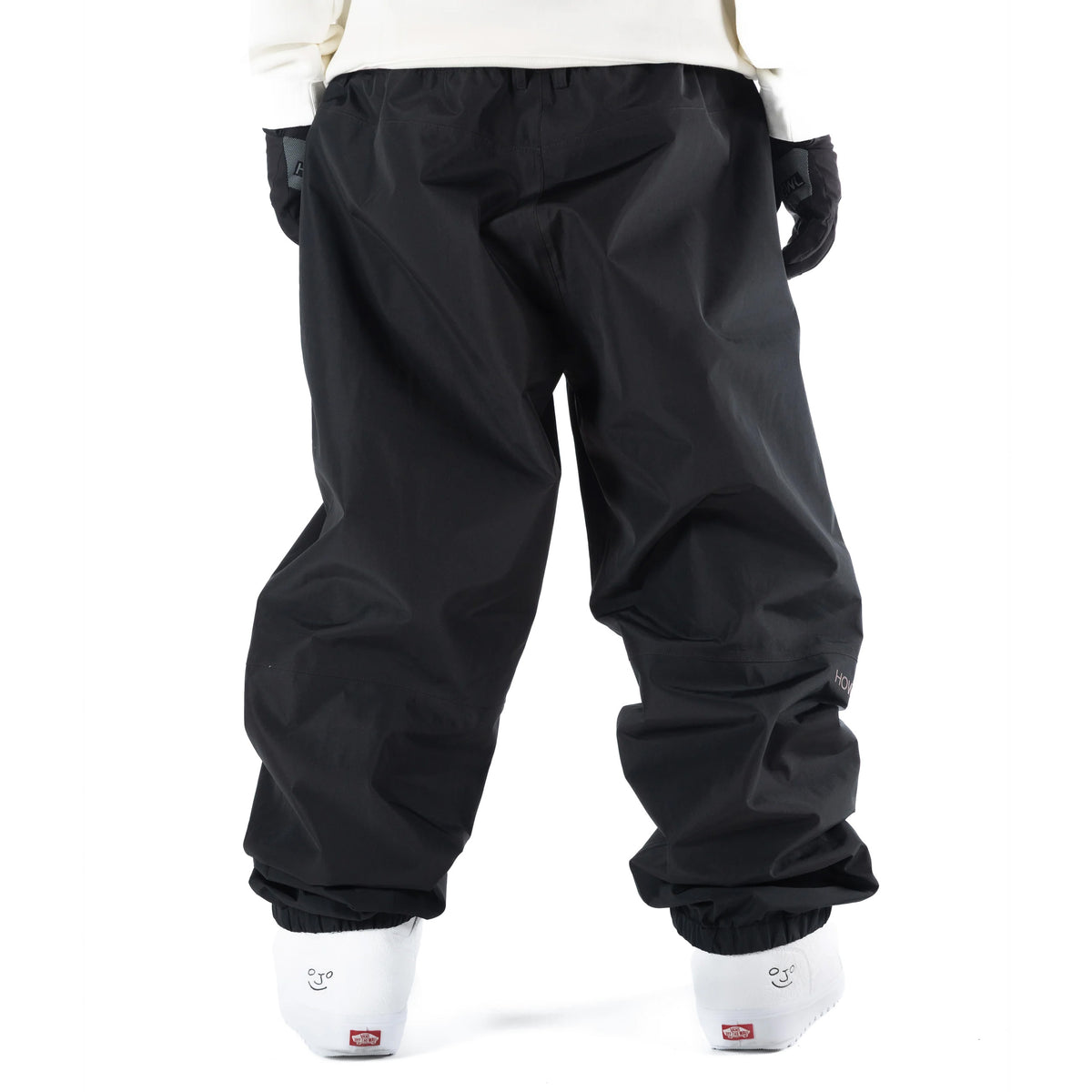 Black Howl Nowhere snowboard pant on mdel with a loose fit back view